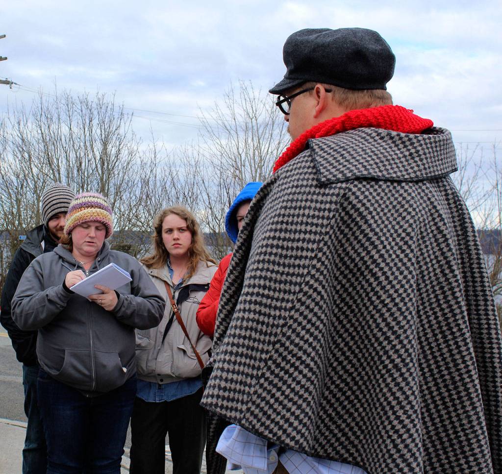 Dr. John Watson, also known as Bob Essex, gets a grilling from Mystery Weekend participants Sunday. That group on the corner was intense, he later said. In the many years Ive done this, I dont think Ive ever been so interrogated. (Photo by Patricia Guthrie/Whidbey News Group)