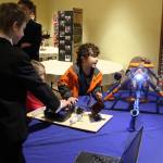 Slater Canright, left, helps Morphew Momo Jenkins operate the underwater robot he built that is equipped with a video camera.