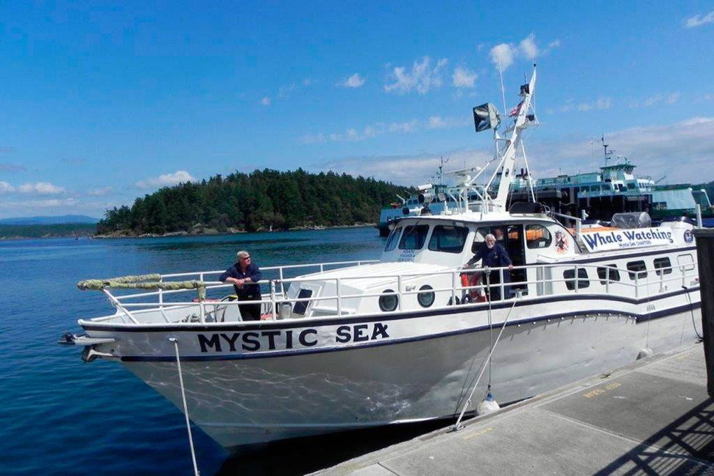 Capt. Monte Hughes, in the bow, and crew member Dick Snowberger wait for the M/V Mystic Sea to pass an inspection. (Photo by Sandra Pollard)