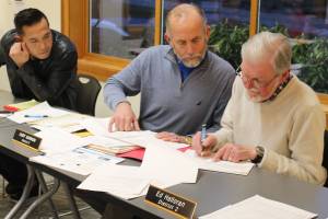 Port of South Whidbey commissioners Jack Ng, left, Curt Gordon and Ed Halloran review a list of grant application requests before announcing their decision at a meeting.