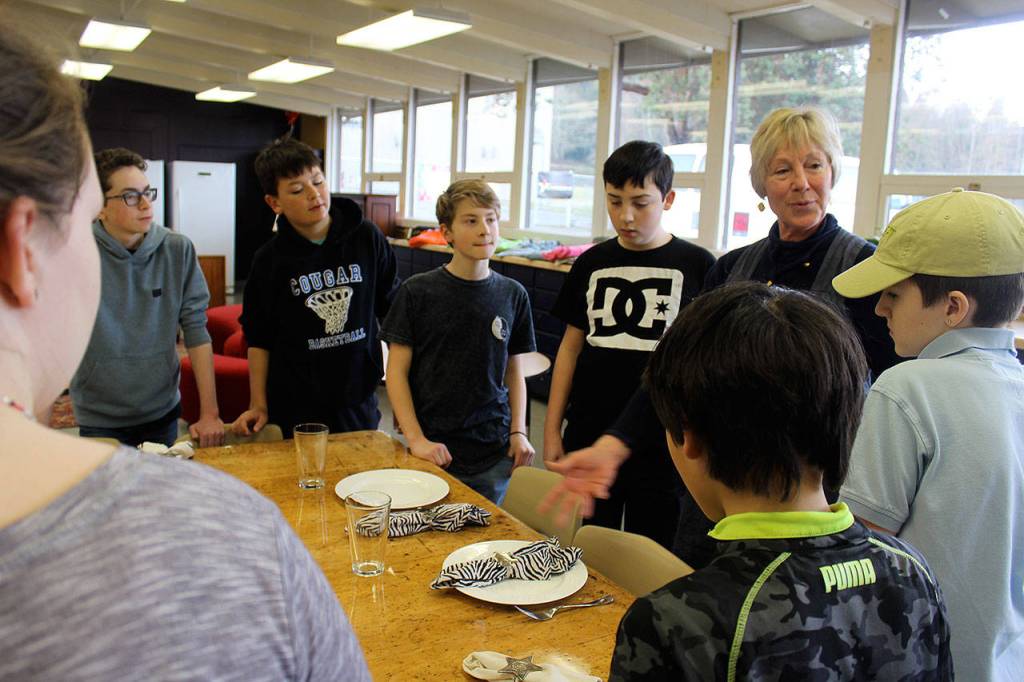 Mary Lou Whisenand teaches how to set a table, one of many life skills middle school students acquire during Learning Lab activities.