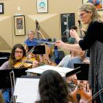 Conductor Anna Edwards rehearses with two orchestras that will jointly perform April 6 at South Whidbey High School for the concert, Musical Metamorphosis. They practiced at Roosevelt High School in Seattle, where the concert will be performed the day before. (Photo provided)