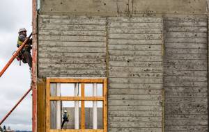 Construction workers begin taking off the outside wall braces of the terminal building at the site of the new Mukilteo ferry terminal. (Olivia Vanni / The Herald)