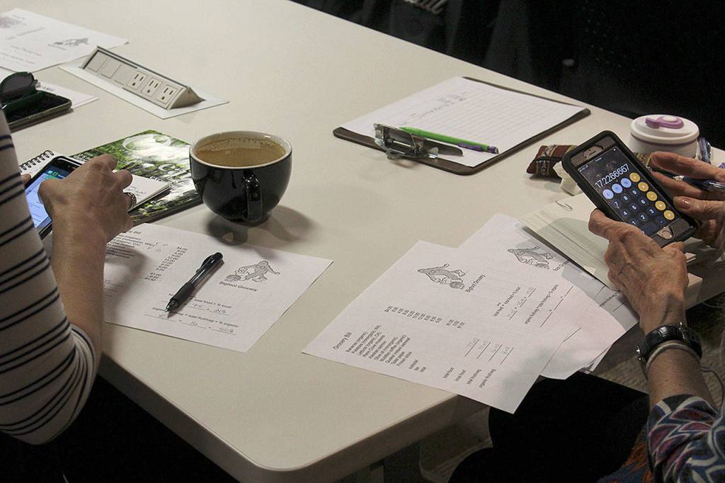 Participants in Taming Bigfoot Whidbey learned how to calculate the carbon footprint of their daily activities during a workshop Thursday. (Photo by Patricia Guthrie/Whidbey News Group)