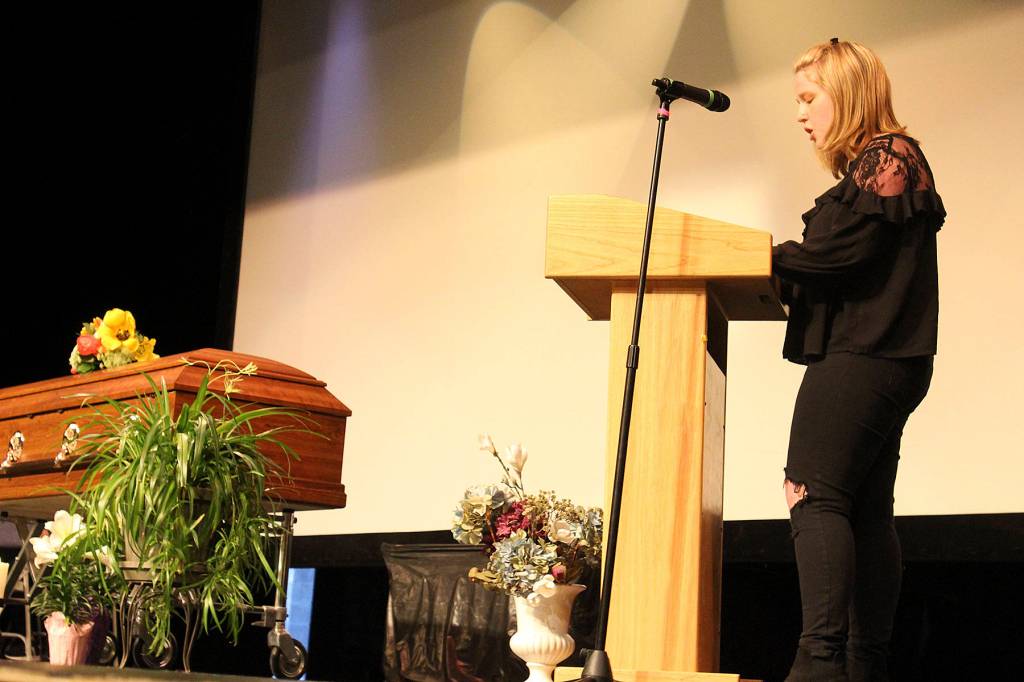 Student Isabelle Bolding speaks at the mock memorial service that included a real casket on stage.