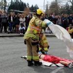 South Whidbey Fire/EMS responders place a white sheet over victim Emma Gilbert who died from head injuries after being thrown through the windshield of a car driven by her pretend and real  boyfriend, Aryeh Rohde. Leadership students organized the demonstration that also involved an assembly. (Photo by Patricia Guthrie/Whidbey News Group)