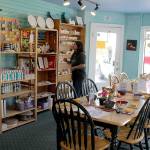 Owner Carol Evans arranges shelves at the new Langley location of Whidbey Art Escape, a paint-your-own ceramics outlet that had been in Freeland for more than a decade. (Photo by Patricia Guthrie/Whidbey News Group)