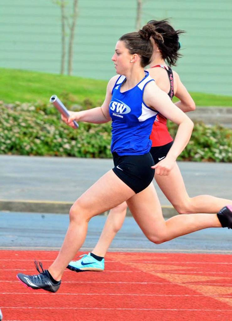 Karyna Hezel carries the baton for the South Whidbey relay team.(Photo by Karen Swegler)