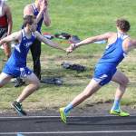 Max Dodd hands off to Cody Eager in the 4x400 relay.(Photo by John Fisken)