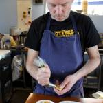 Trap Landry, chef and co-owner of Anthes Ferments in Langley, fills french-style cheese pastries with his mix of nettle pistachio pesto that will be paired with Comforts of Whidbey High Tide White. (Photo by Patricia Guthrie/Whidbey News Group)