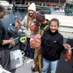 With limited days to catch spot shrimp, students sometimes skip school and adults play hooky from work, which is exactly what the Keyser family from Everett did Wednesday. Here, they show off the rewards of a successful spot shrimp expedition while docked at the Langley marina. (Photo by Patricia Guthrie/Whidbey News Group)