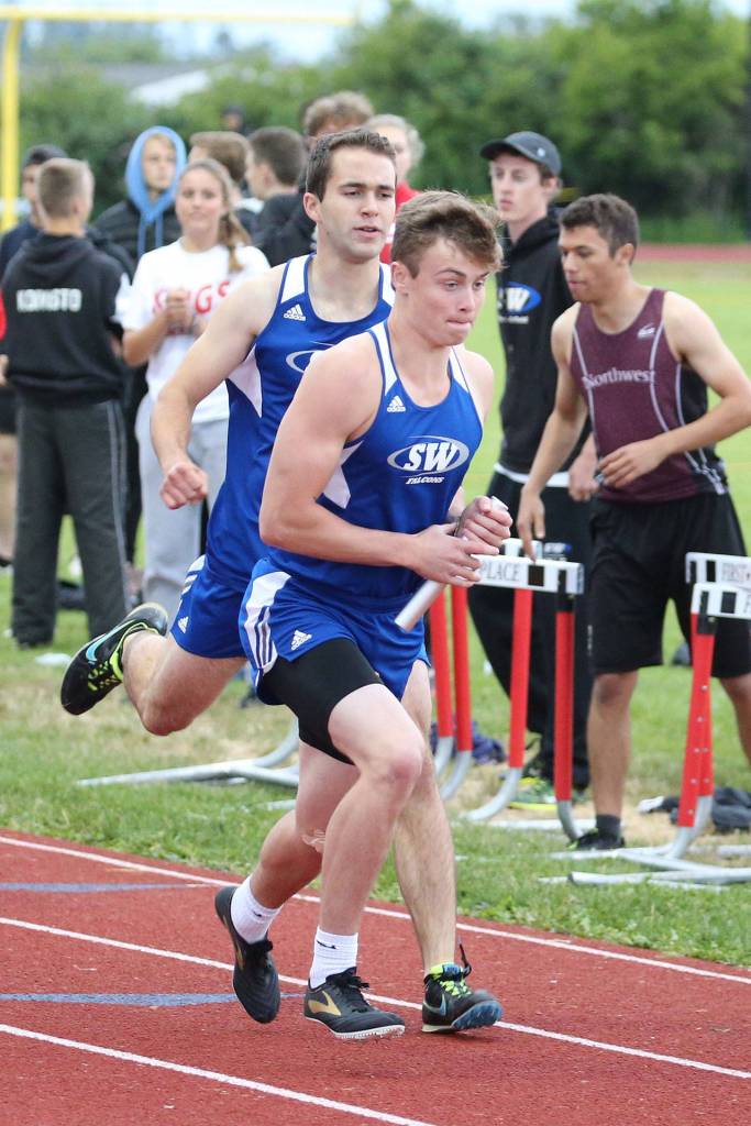 Max Dodd handes off to Bodie Hezel in the preliminaries of the 4x400 relay.(Photo by John Fisken)
