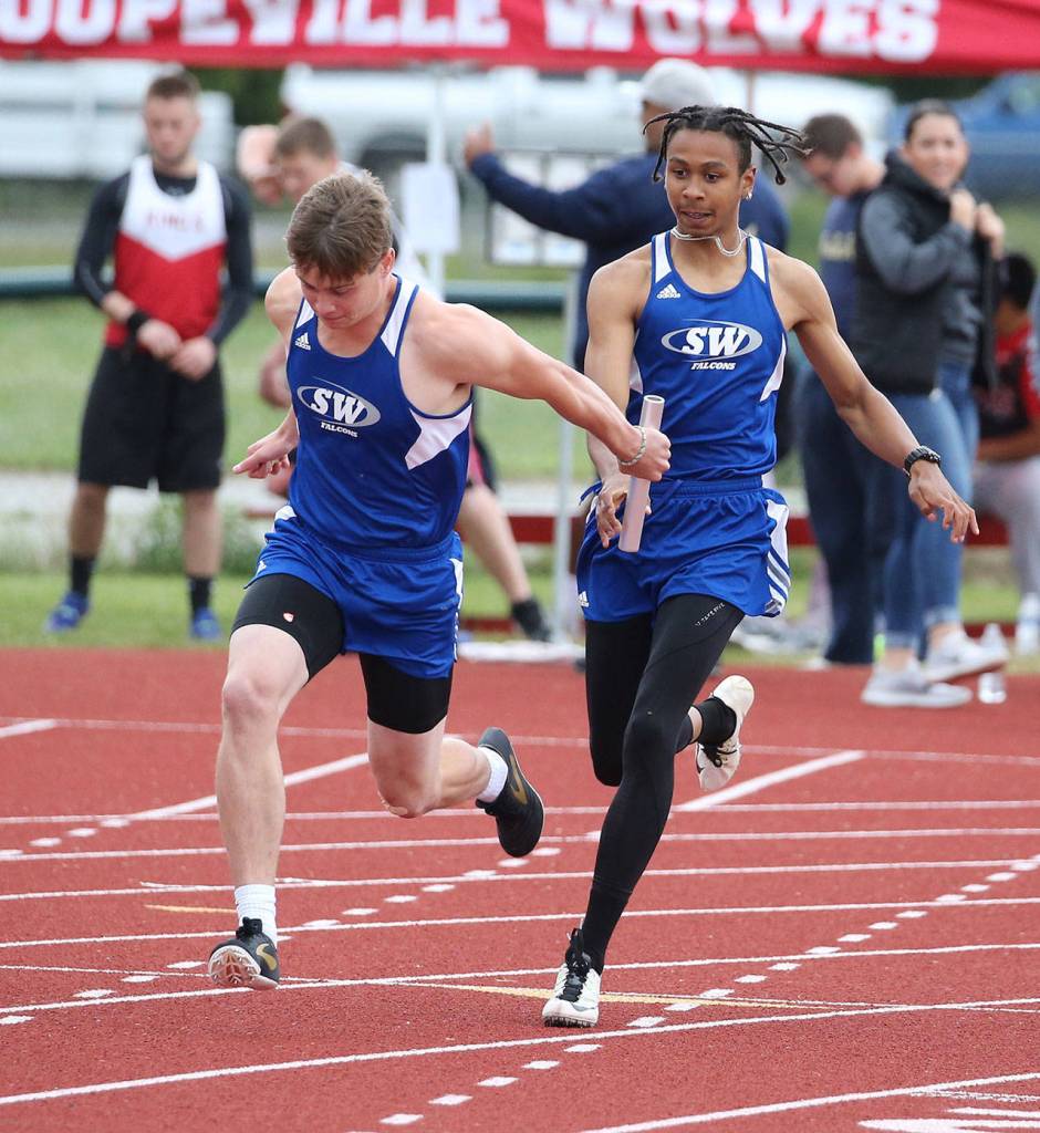 Issiah Gonzales hands the baton to Bodie Hezel in the 4x100 relay.(Photo by John Fisken)
