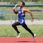 Issiah Gonzales runs the first leg for the winning 4x100 team.(Photo by John Fisken)