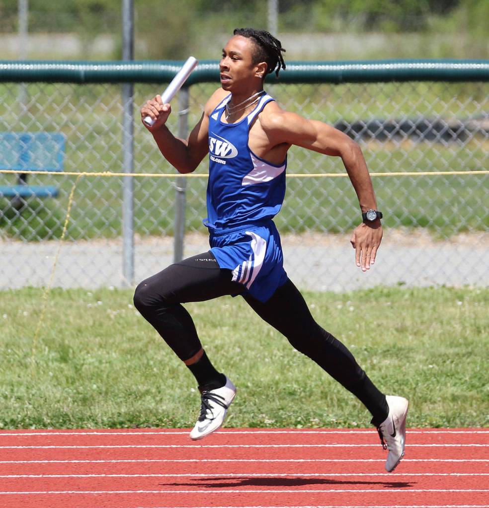 Issiah Gonzales runs the first leg for the winning 4x100 team.(Photo by John Fisken)