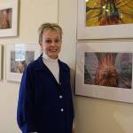 Marie Plakos stands with her work at the Bayview Corners Front Room Gallery. Her photos explore the feminine in nature, she said. Photo by Maria Matson/Whidbey News Group