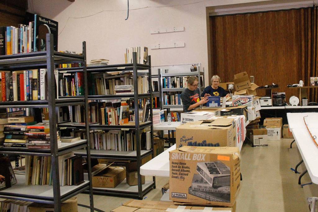 (Photo by Maria Matson/Whidbey News Group)                                MacKenzie Davis (left) and Lion Marilyn Engel work on sorting books.