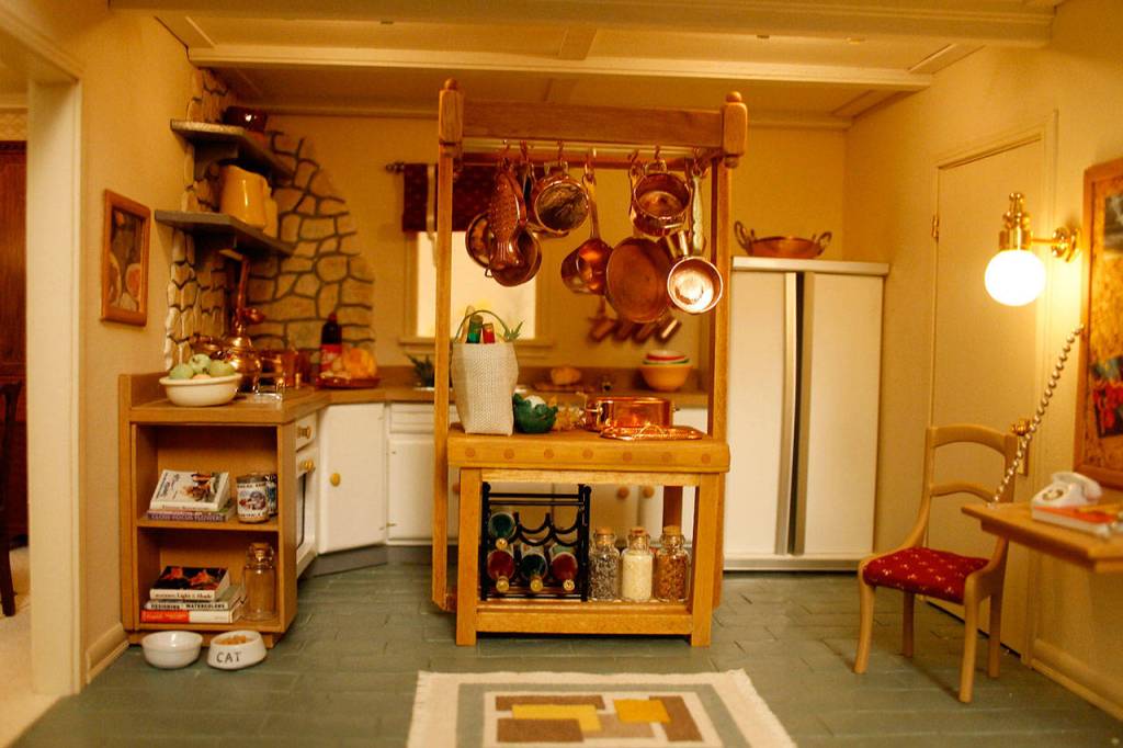 In the kitchen, the doors of the refrigerator open to reveal fully-stocked shelves.