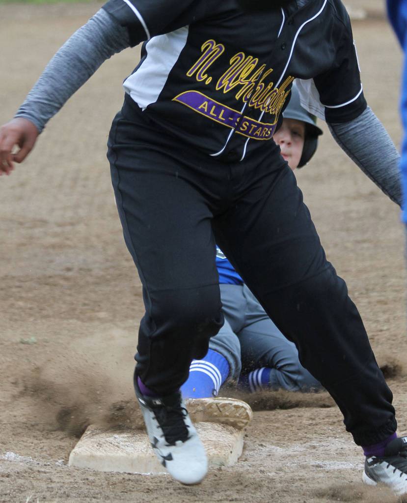 Sage Northrup sneaks into third base as the ball gets by North Whidbeys Daniel Richey.(Photo by Jim Waller/South Whidbey Record)