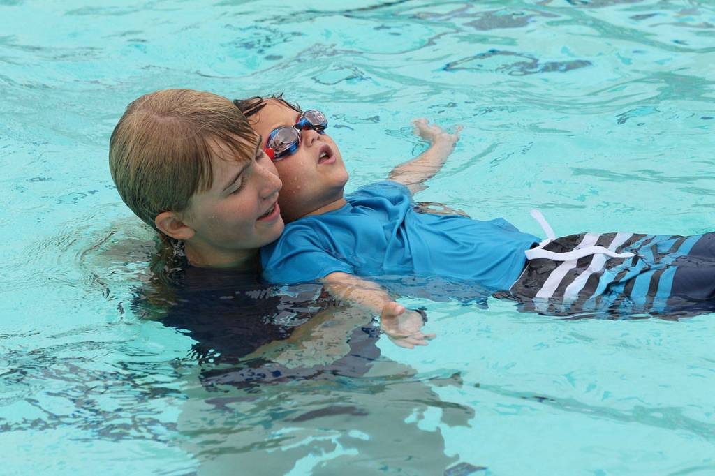Caitlin Sullivan helps Dreyke Mendiola with his back float.(Photo by Jim Waller/South Whidbey Record)