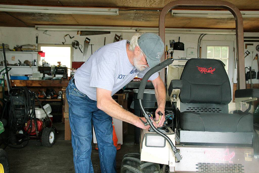 Gary Formhals tinkers with a piece of machinery at Fort Casey State Park. He is known fo rhis handiness and fixing things around the park, which is part of the he received the Award for Excellnce.