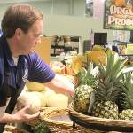 Employee Seth Haynie stocks organic produce at The Goose Community Grocer in Bayview