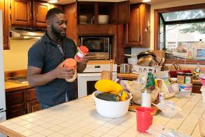 Shaquille Walker, youth advocate at Ryans House for Youth, helps clean the kitchen at the drop-in center.