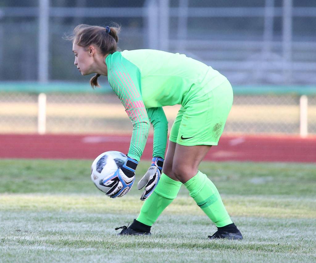Nicole Helseth scoops up the ball for South Whidbey.(Photo by John Fisken)