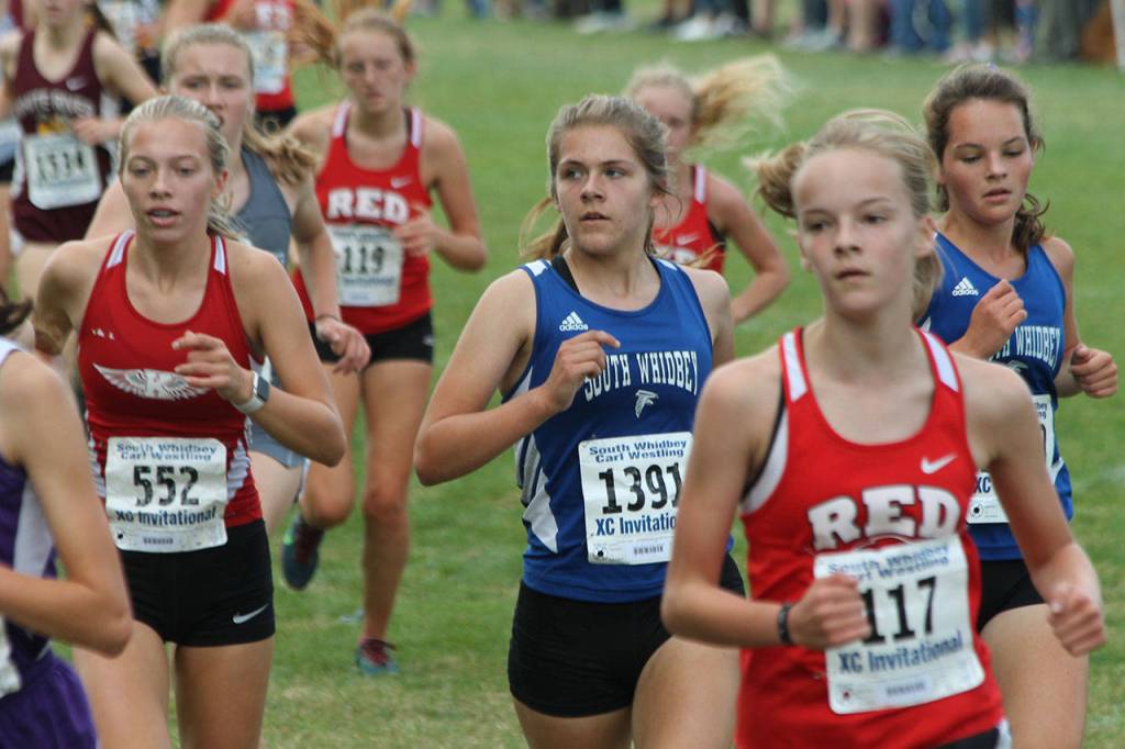 Falcons Grace Huffman (1391) and Jasmin Graner, right, complete the first lap of the course.(Photo by Jim Waller/South Whidbey Record)
