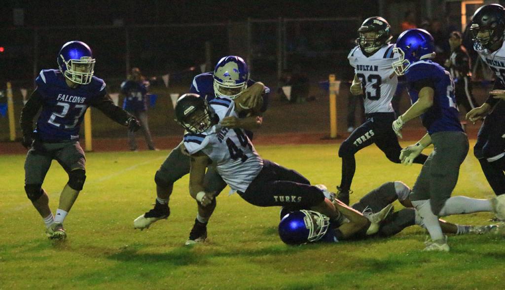 Kobe Balora hits Sultan ball carrier Kaden Hardwick (44) high while Alex Black snags his legs.(Photo by Jim Waller/South Whidbey Record)
