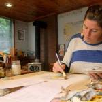 Photo by Kira Erickson / South Whidbey Record                                Anna Cosper paints a design for a commissioned holiday card in her studio.