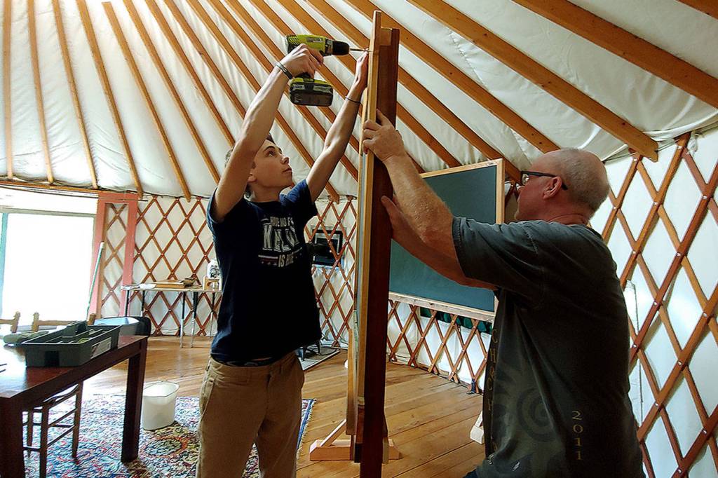 Photo courtesy of Marli Jenkins                                Woodhaven Faculty Liaison Kent Ratekin and freshman Kelvin Jenkins putting together a chalkboard at the Organic Farm School classroom.