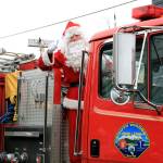 Santa flashes a thumbs-up from a fire truck on First Street. He hitched a ride with firefighters and other first responders with the South Whidbey Fire/EMS during the annual Holly Jolly Parade in Langley Saturday. Old St. Nick traditionally joins the department in the popular parade that draws several hundred marchers from a wide range of groups. Island County Commissioner Helen Price Johnson was this years grand marshal.