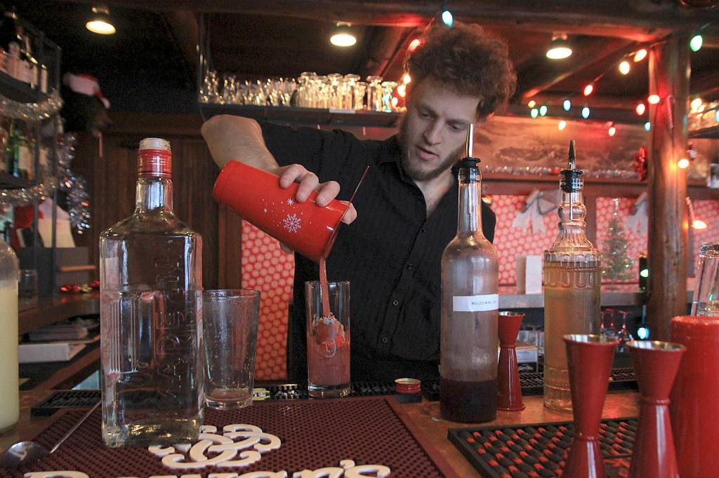 Photo by Laura Guido/Whidbey News Group                                Captain Whidbey Inn bartender Aaron Bloom mixes a specialty cocktail as part of the Christmas pop-up Miracle. As part of the inns holiday-themed events, community members are invited to help decorate the tree in the lobby, a revival of an old tradition.