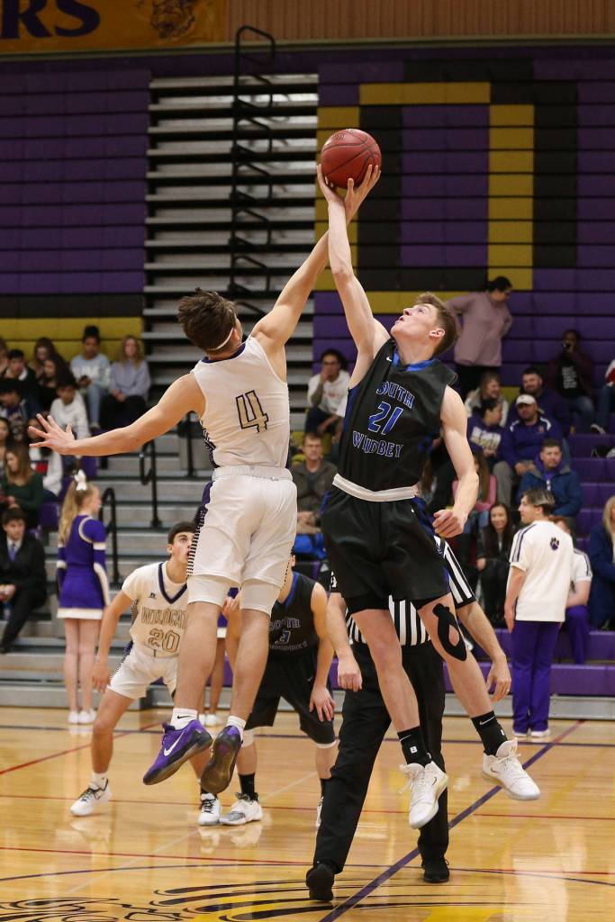 Carson Wrightson, left, tips off against Oak Harbors Mason Myers.(Photo by John Fisken)