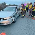 Apparatus Operator Ed Pratt, of Central Whidbey Island Fire and Rescue, uses a hydraulic rescue tool to remove a door from the heavily damaged door of a sedan involved in a hit-and-run accident Thursday. Photo provided by Central Whidbey Island Fire and Rescue