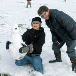 Weston Dill and Dominic Collver-Horvath show off a snow creation they built together during recess.
