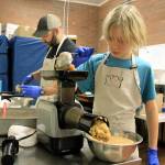 Photo by Kira Erickson/Whidbey News Group                                Caeleb Wiph, one of WINs youngest volunteers, helps make applesauce on Jan. 29.