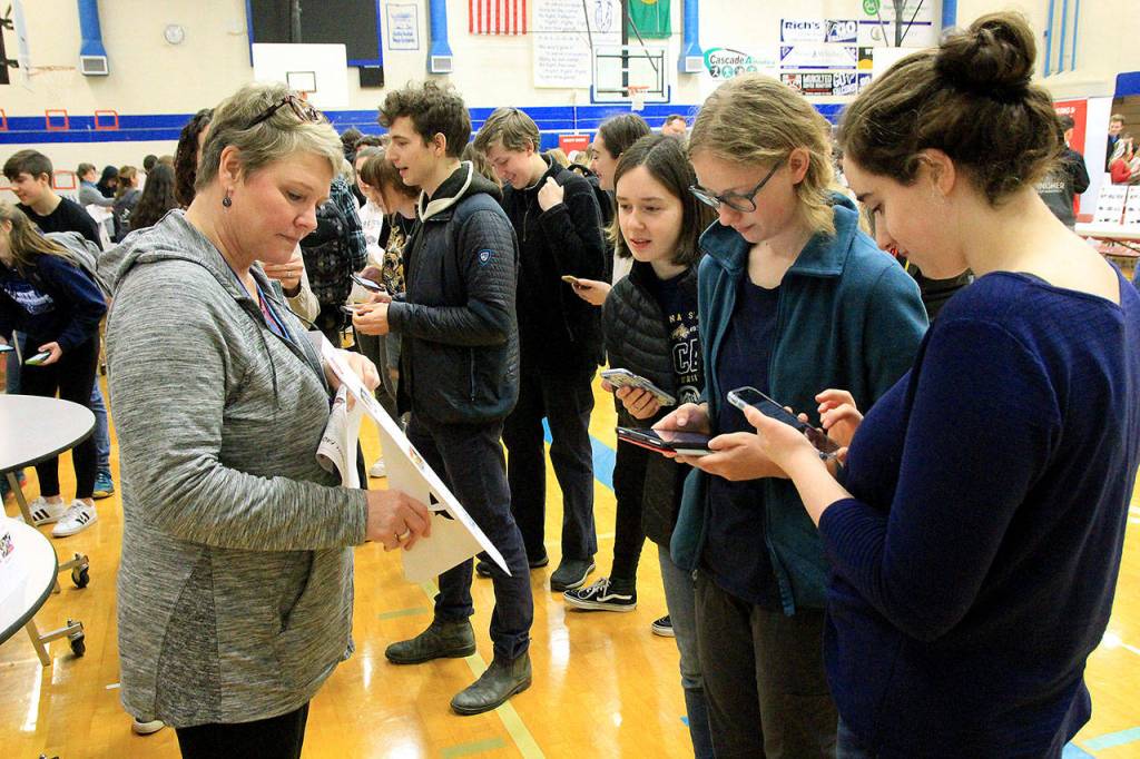 Photo by Kira Erickson/Whidbey News Group                                Volunteer Tia Reese-Young shows a group of students the different child care options available during the simulation.