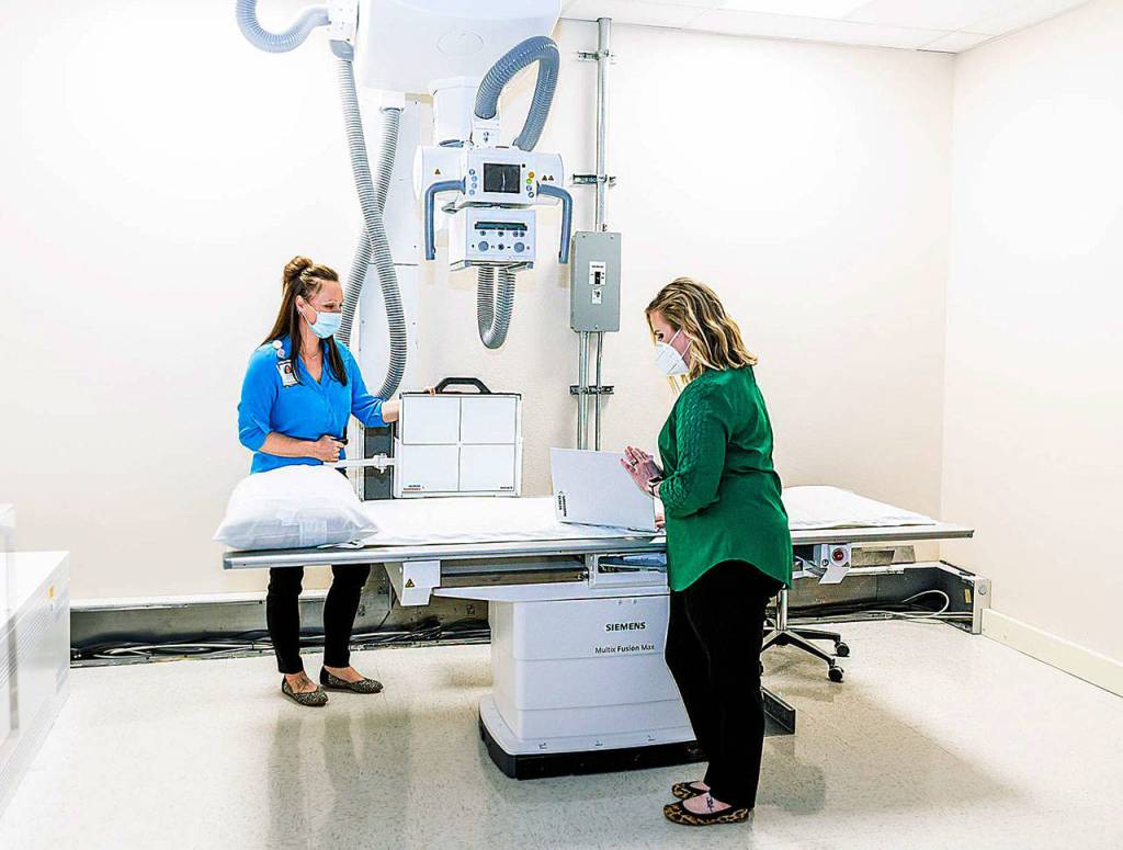 Photo provided                                Jenifer Toner, Supervisor and Jennifer Marcum, Manager of Diagnostic Services, take care of final preparations at Walk-In Clinic Clinton before its opening on Tuesday, June 2.