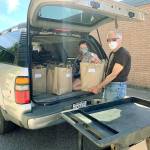 Photo provided                                WIN board member Ted Ravetz and delivery driver Kymy Johnson get ready to deliver food.
