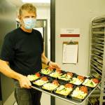 Andreas Wurzrainer, chef and director of the Coupeville School Districts Connected Food Program, lifts a tray with pasta, meatloaf and zucchini. Photo by Kira Erickson/Whidbey News-Times