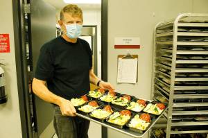 Andreas Wurzrainer, chef and director of the Coupeville School Districts Connected Food Program, lifts a tray with pasta, meatloaf and zucchini. Photo by Kira Erickson/Whidbey News-Times