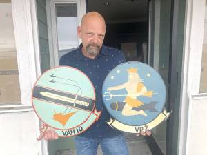 Photo by Emily Gilbert/Whidbey News-Times.Kenneth Peplinski bought both the builidng and the business of the Oak Harbor Tavern, which included all of the military memorabilia donated by patrons over the years, including these two squadron signs that are decades old. He had to leave the taverns old building because he fell behind on payments, but he hopes to reopen the business in a new location in downtown Oak Harbor.
