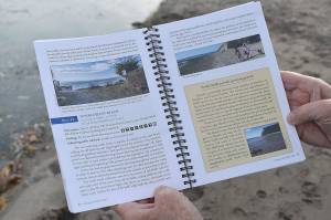 Jeanie McElwain opens the third edition of Getting to the Waters Edge to popular South Whidbey beach Double Bluff. More than 50 volunteers made the current book possible. Photo by Emily Gilbert/Whidbey News-Times