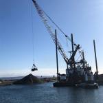 Dredging at Keystone Harbor is done every three to five years by the U.S. Army Corps of Engineers. A clam-shell dredge scoops the sediment and deposits it further up the beach. Photo by Jessie Stensland/Whidbey News-Times