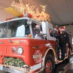 Santa and his elves, Jen Porter and Dalton Martin, have begun decorating Central Whidbey Fire and Rescues Santa Mobile, which begins making the rounds on Dec. 7. Photo by Emily Gilbert/Whidbey News-Times.