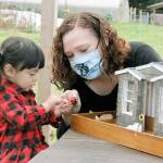 Photo by Kira Erickson/South Whidbey Record
Sarah Santosa and her two-year-old daughter, Gwendolyn, play with a miniature chocolate fondue pot that is part of the miniature storefront for Sweet Monas Chocolates in Langley. The little chocolate shop is the third model in a series built by Santosa for Langley businesses.