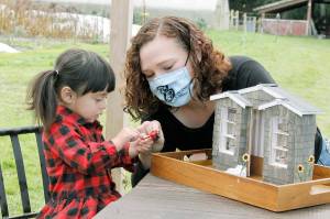 Photo by Kira Erickson/South Whidbey Record
Sarah Santosa and her two-year-old daughter, Gwendolyn, play with a miniature chocolate fondue pot that is part of the miniature storefront for Sweet Monas Chocolates in Langley. The little chocolate shop is the third model in a series built by Santosa for Langley businesses.