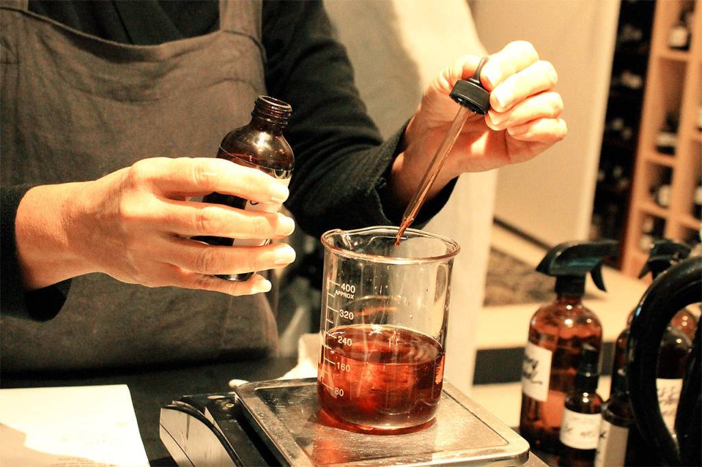 Karen Wilson adds to the palo santo blend of oils. Photo by Kira Erickson/South Whidbey Record
